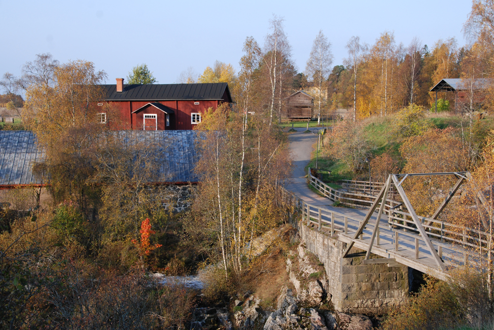 Kuvassa kosken ylittävä silta ja museoalueen rakennuksia.