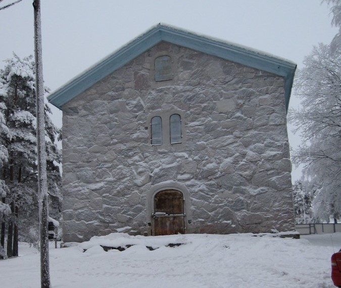 Perttelin kotiseutumuseo on kivisessä sainamakasiinissa. Kuva on otettu talvella, maassa ja rakennuksen seinällä on lunta.