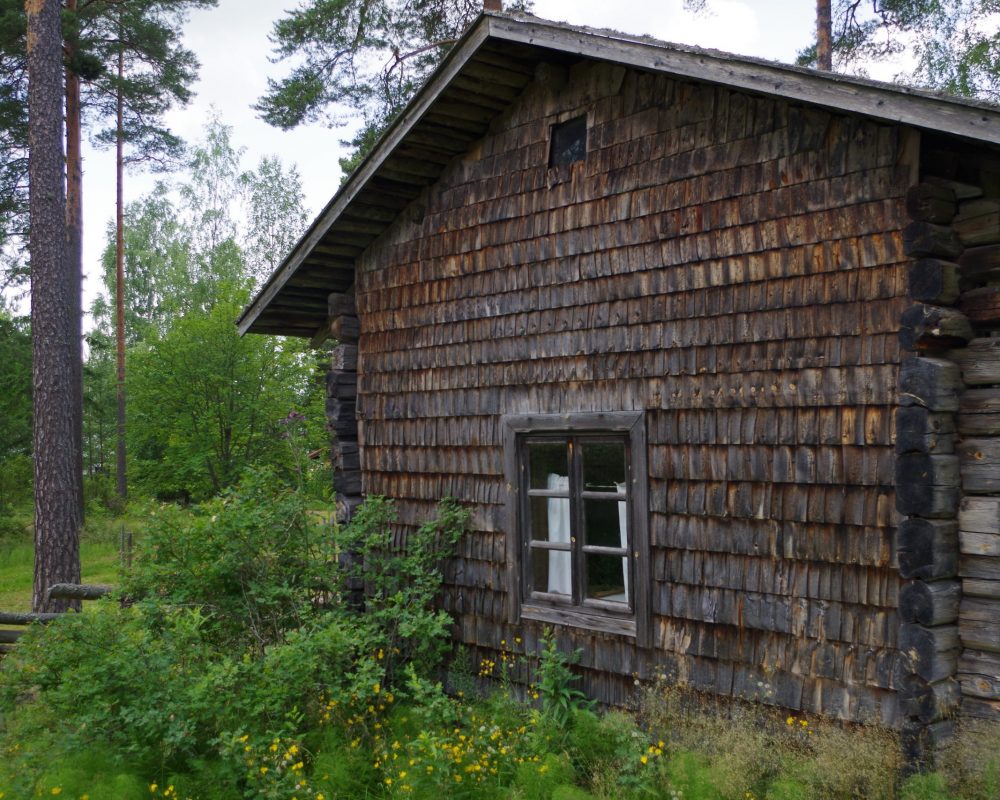 Ruskea rakennus, jossa päreillä päälystetty seinä.