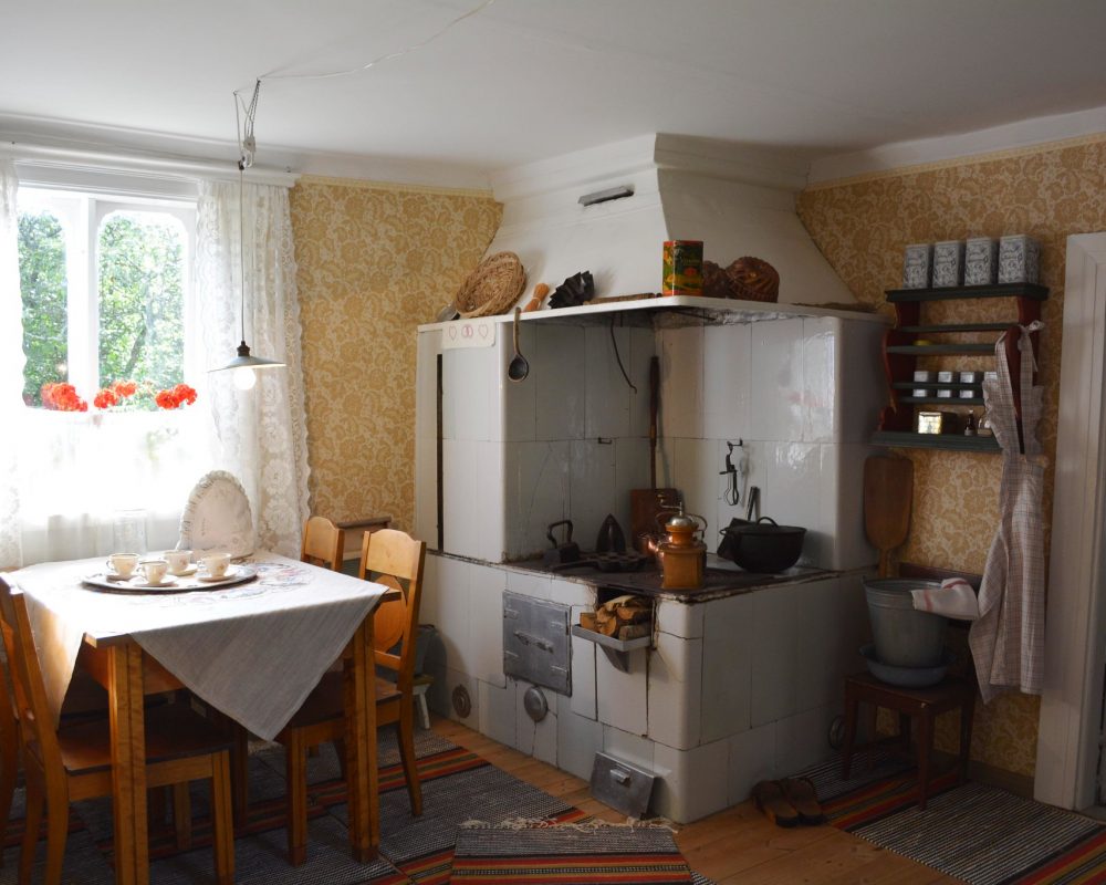 Merimiehenkoti Kuvassa merimiehenkodin tupa, jossa ikkunan alla pöytä ja tuolit neljälle hengelle, ja nurkassa uuni ja hella.